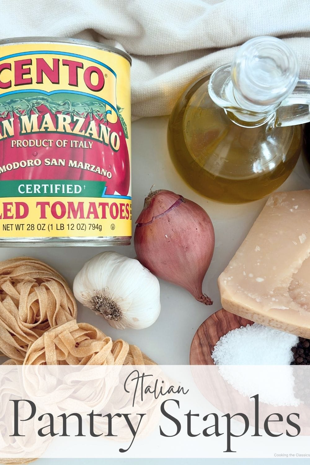 Italian pantry staples including canned San Marzano tomatoes, olive oil, garlic, onion, Parmigiano Reggiano, and dried pasta