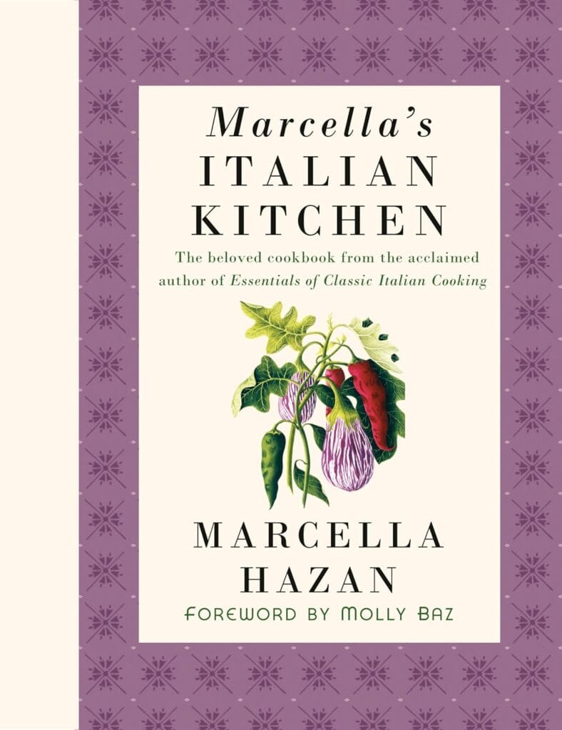 Cover of Marcella’s Italian Kitchen by Marcella Hazan, featuring a purple patterned border, cream center panel, and illustrated eggplants and peppers on the front.