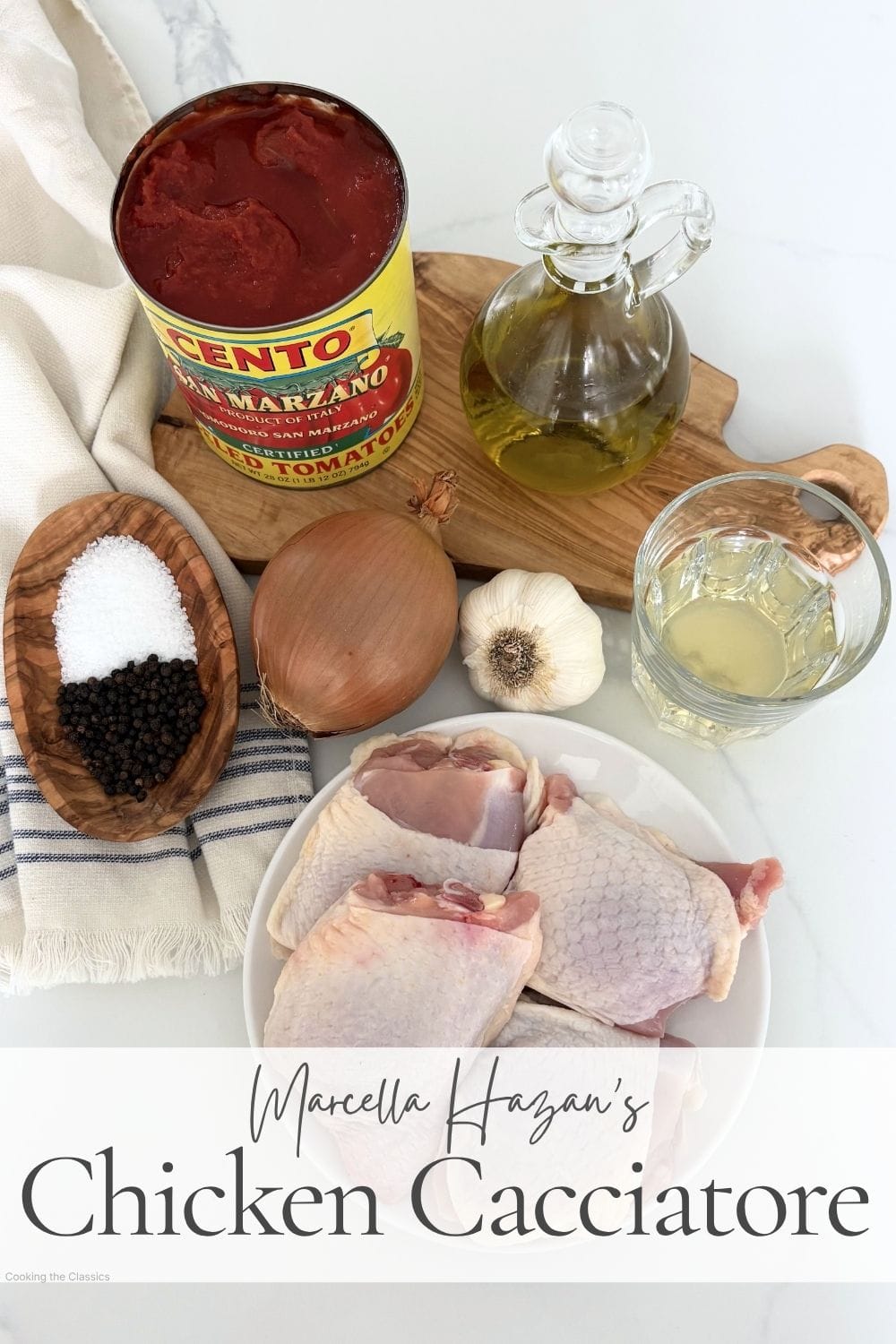 Ingredients for chicken cacciatore including bone in chicken thighs, canned tomatoes, onion, garlic, olive oil, white wine, salt, and pepper