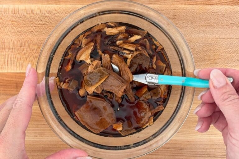 Reconstituting dried porcini mushrooms in warm water until softened