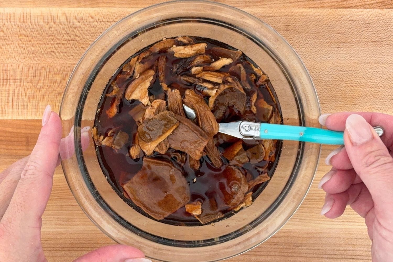 Reconstituting dried porcini mushrooms in warm water until softened