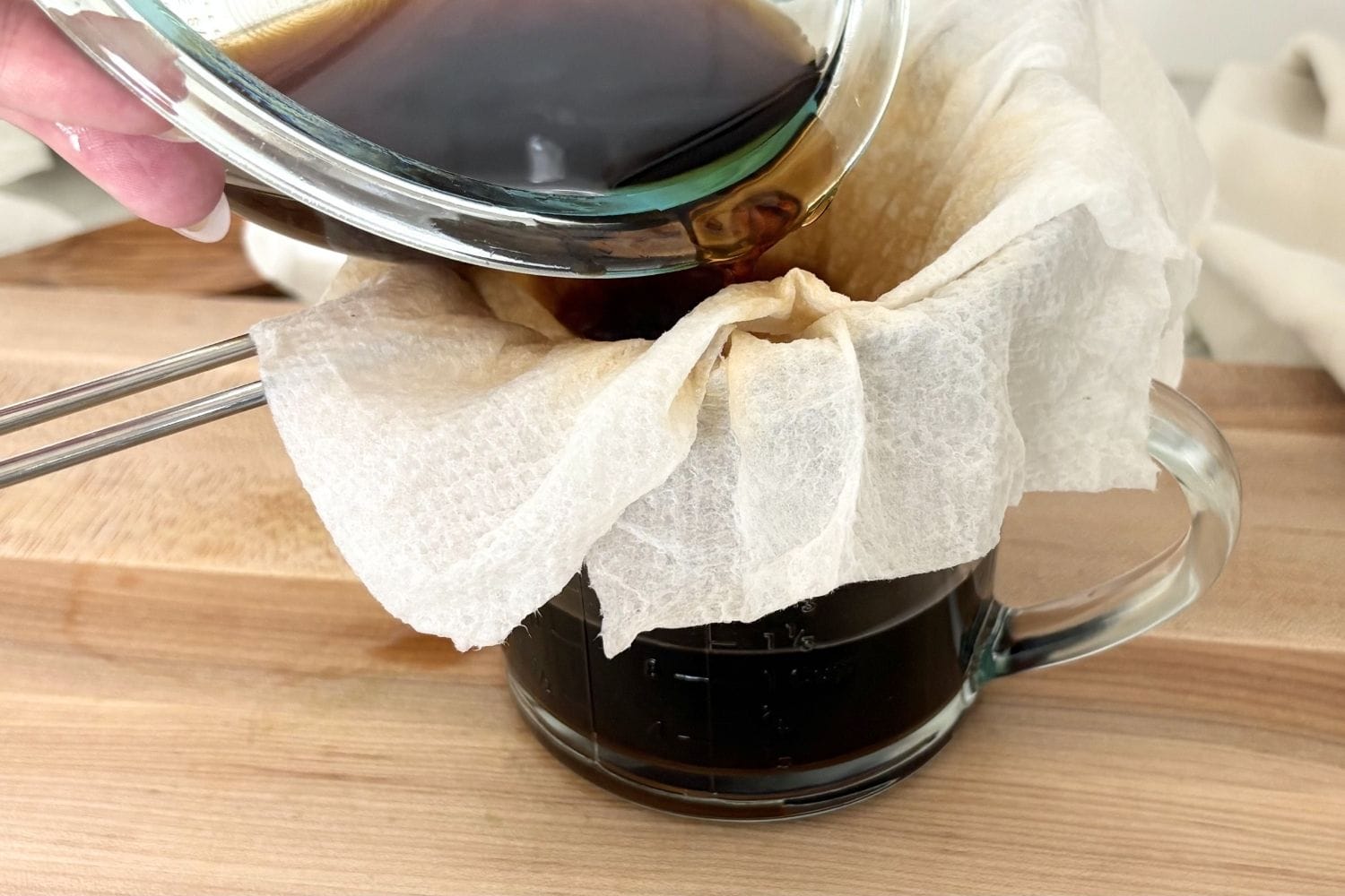 Straining porcini soaking liquid through paper towel to remove sediment