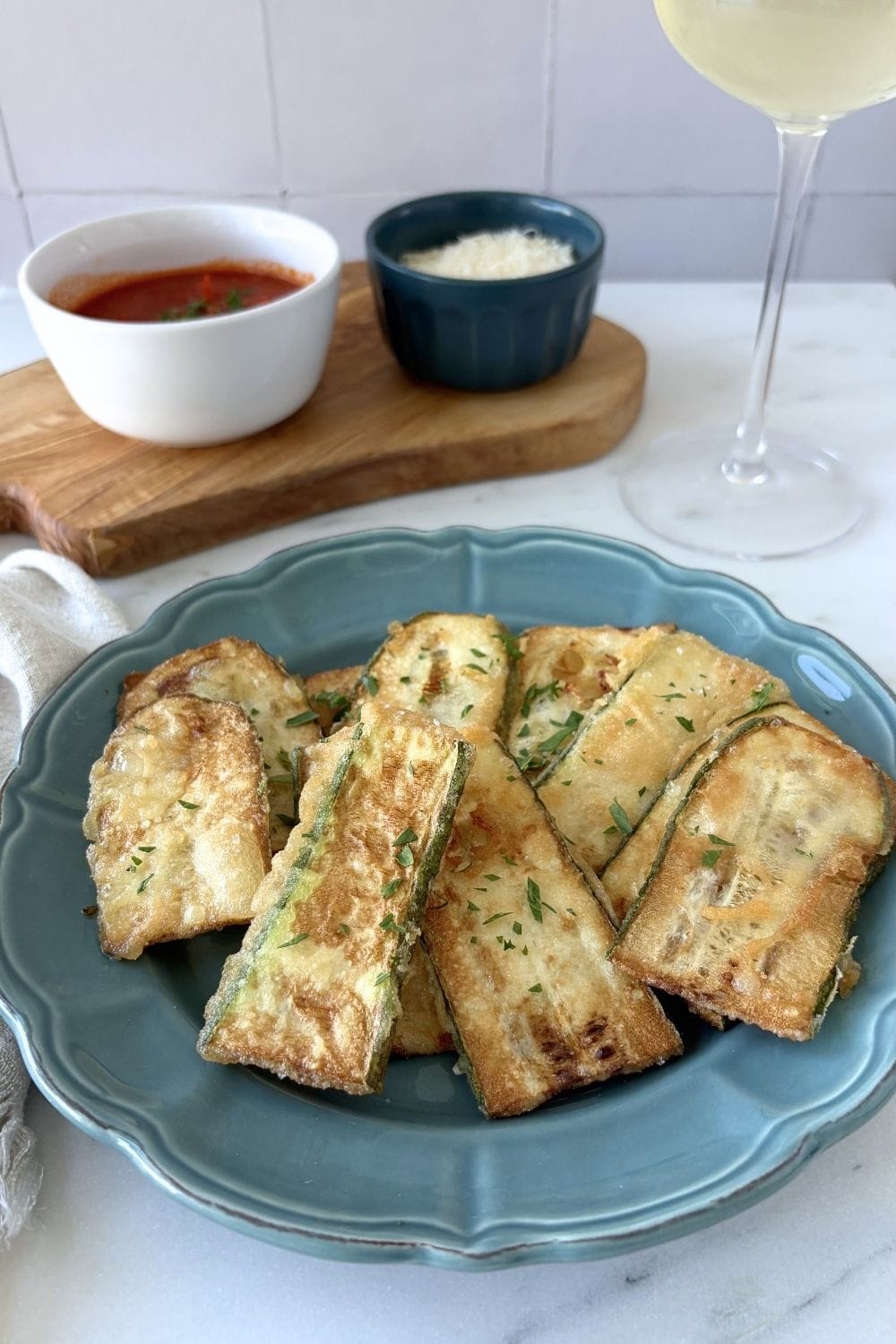 Marcella Hazan’s fried zucchini served with tomato sauce, grated parmesan, and a glass of Prosecco.