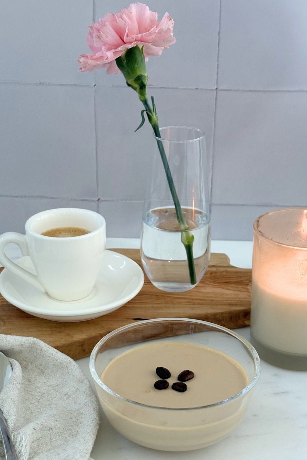 Ricotta and coffee cream dessert served with espresso, candlelight, and a pink flower beside the bowl.