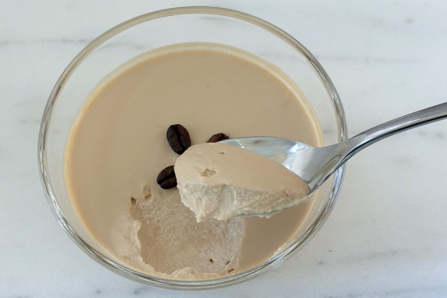 Spoonful of chilled ricotta and coffee cream dessert showing the smooth, mousse-like texture.