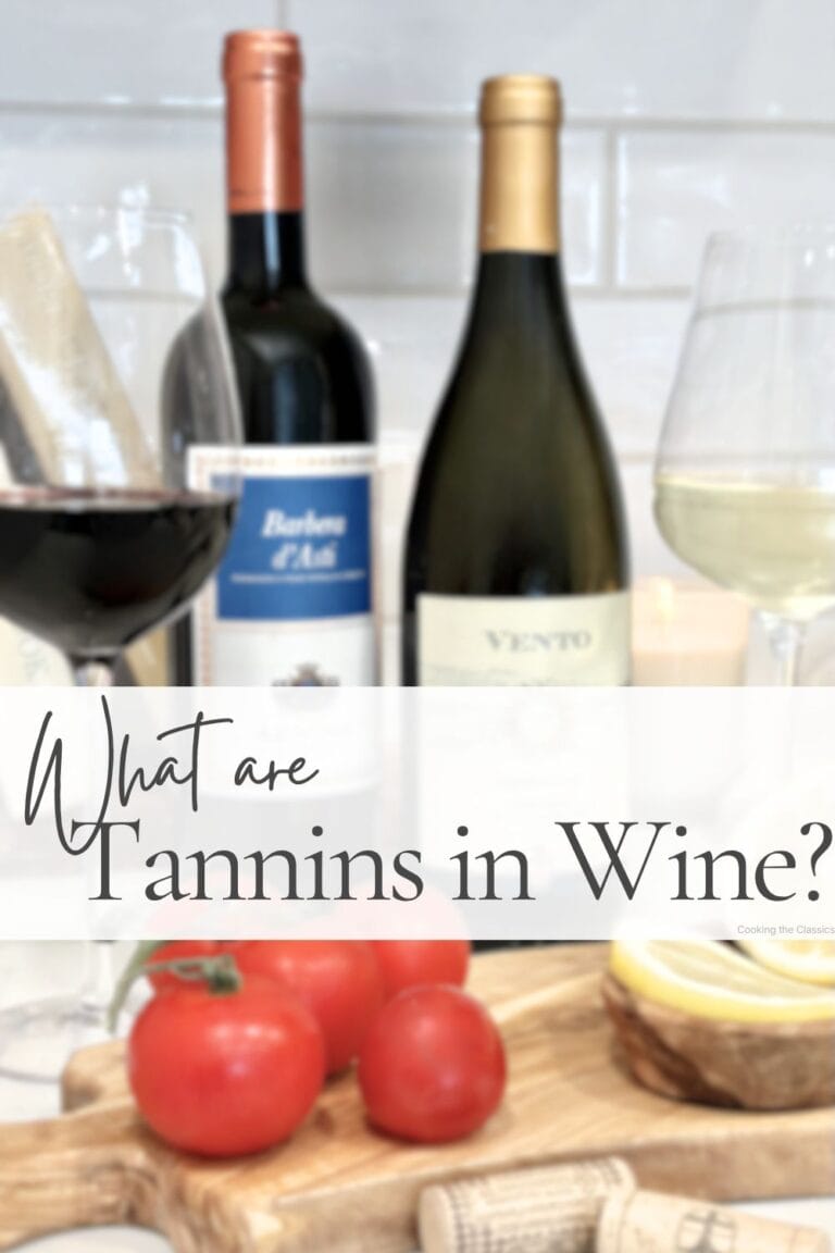 Wine guide graphic titled “What are Tannins in Wine?” featuring red and white wine bottles, wine glasses, tomatoes, and lemons on an olive wood board with a soft white text overlay.