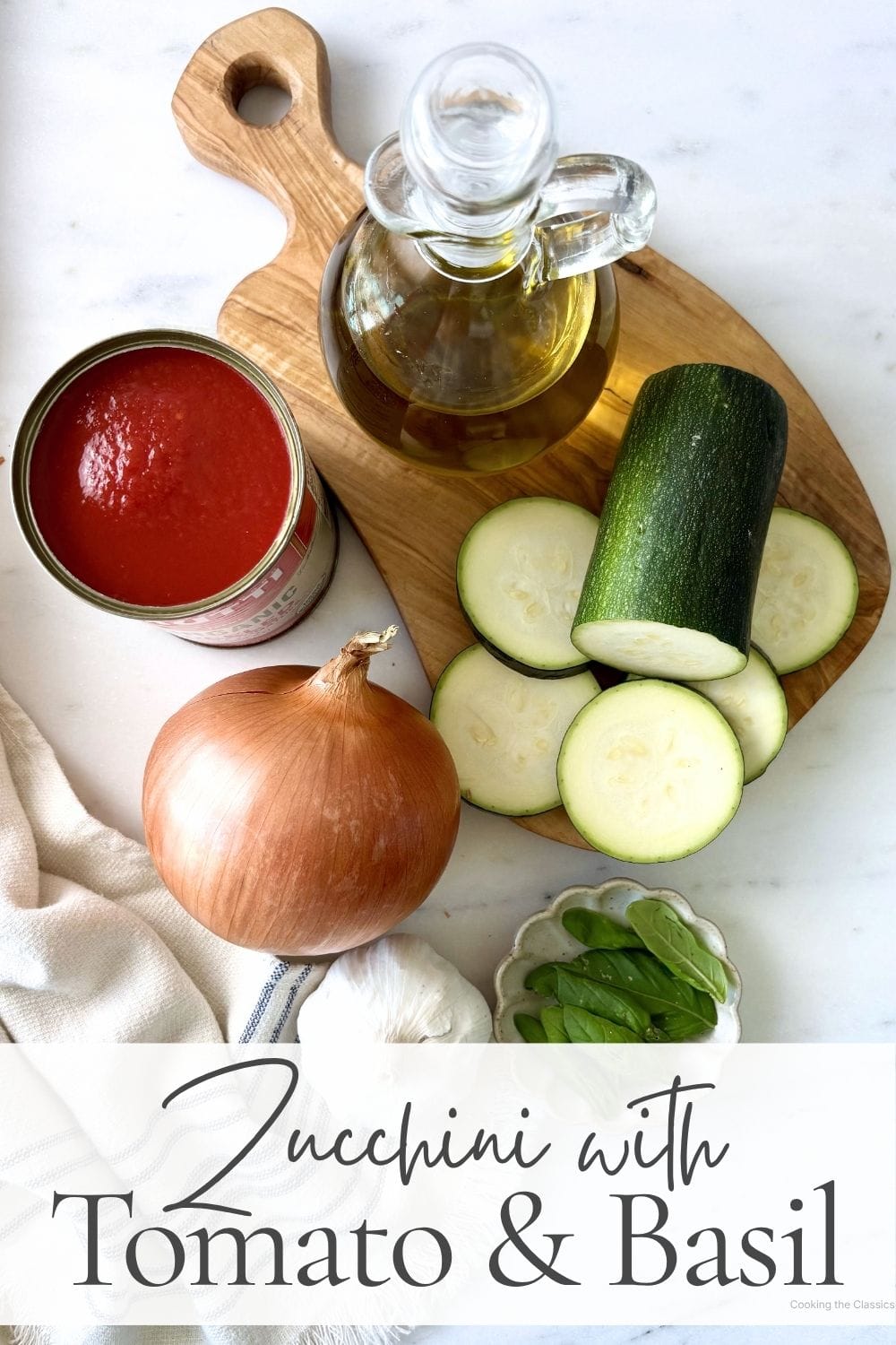 Ingredients for zucchini with tomato and basil including zucchini, canned tomatoes, onion, garlic, olive oil, and fresh basil