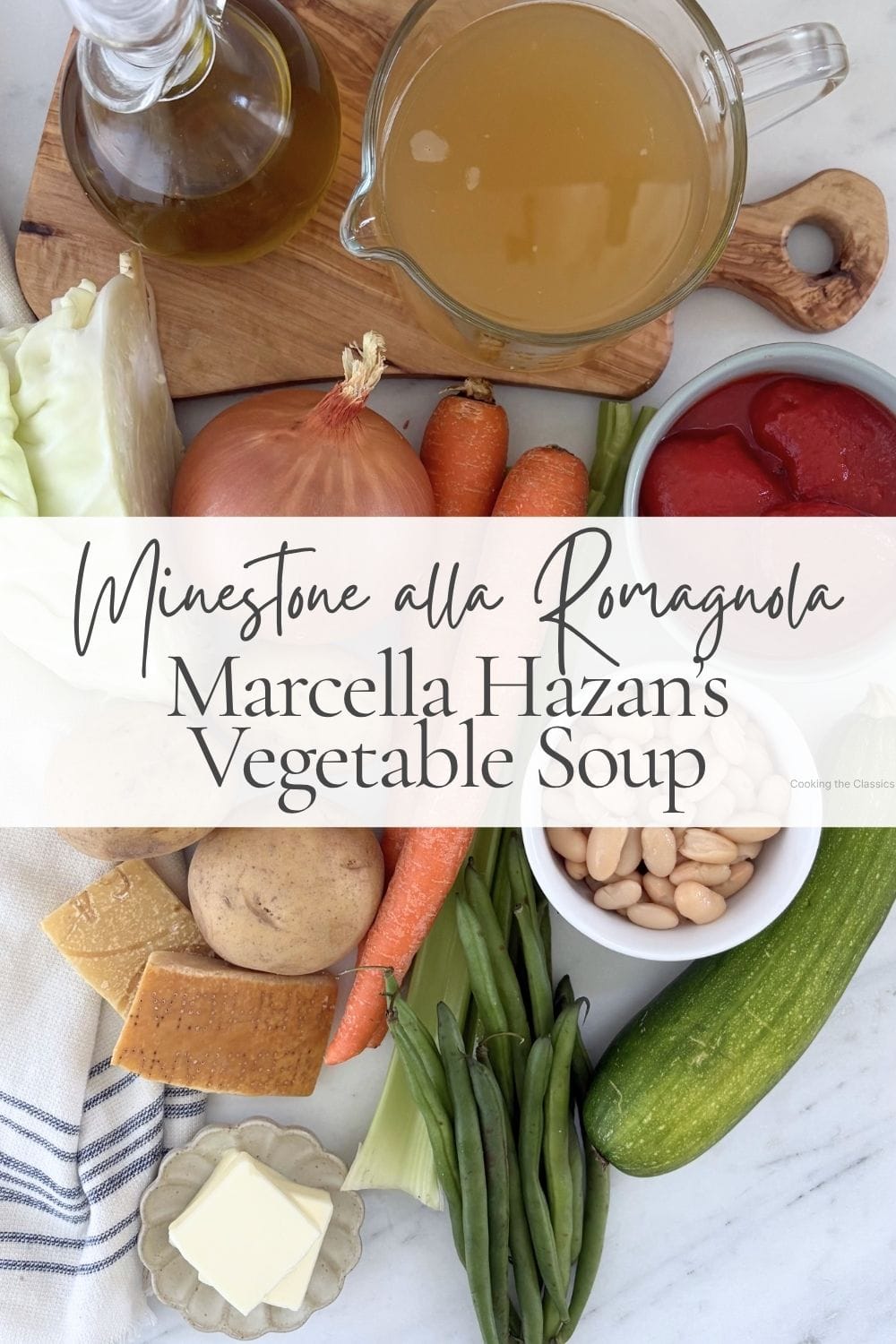 Ingredients for Minestrone alla Romagnola including vegetables, white beans, tomatoes, broth, Parmigiano-Reggiano, butter, and olive oil arranged on a marble countertop.