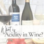 Pin graphic titled "What is Acidity in Wine?" featuring red and white wine glasses, wine bottles, tomatoes, and lemon slices on a wooden board.