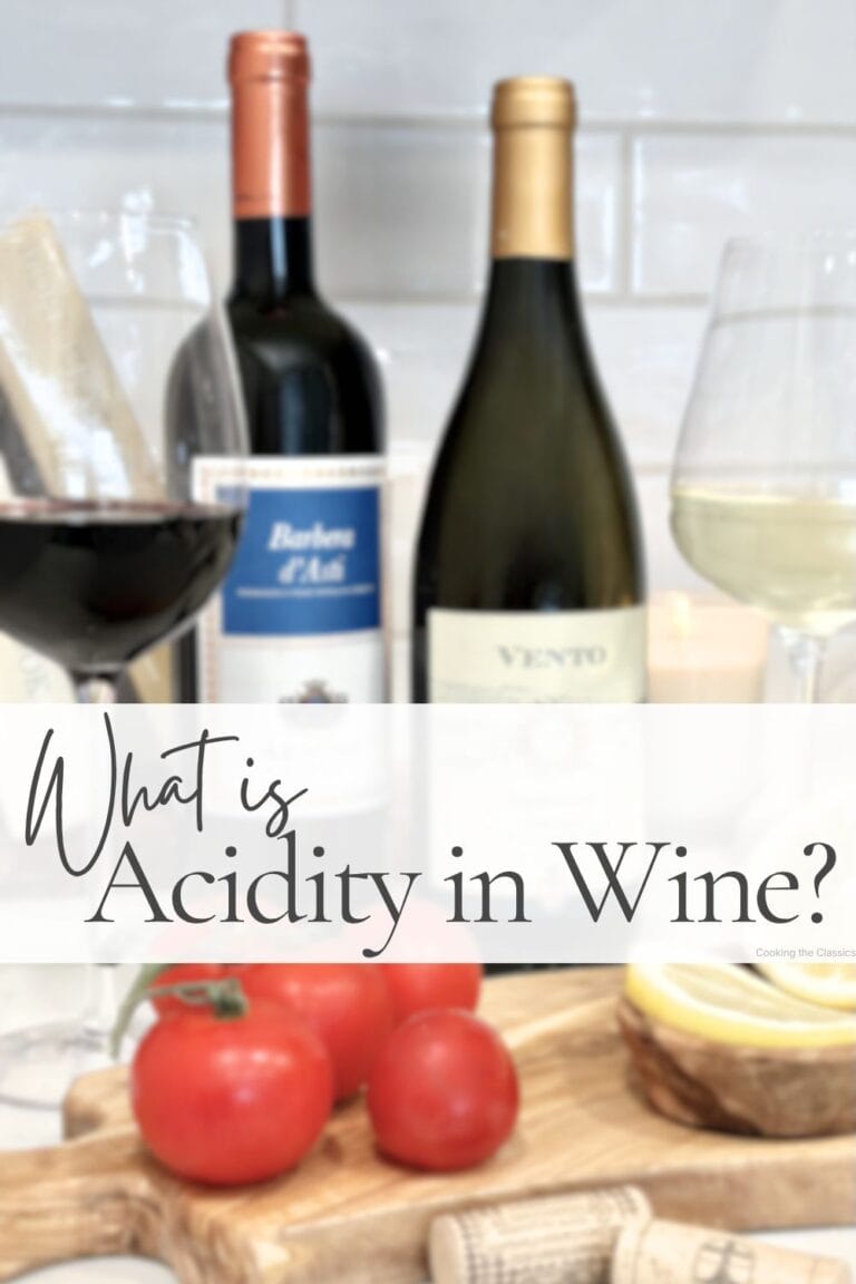 Pin graphic titled "What is Acidity in Wine?" featuring red and white wine glasses, wine bottles, tomatoes, and lemon slices on a wooden board.