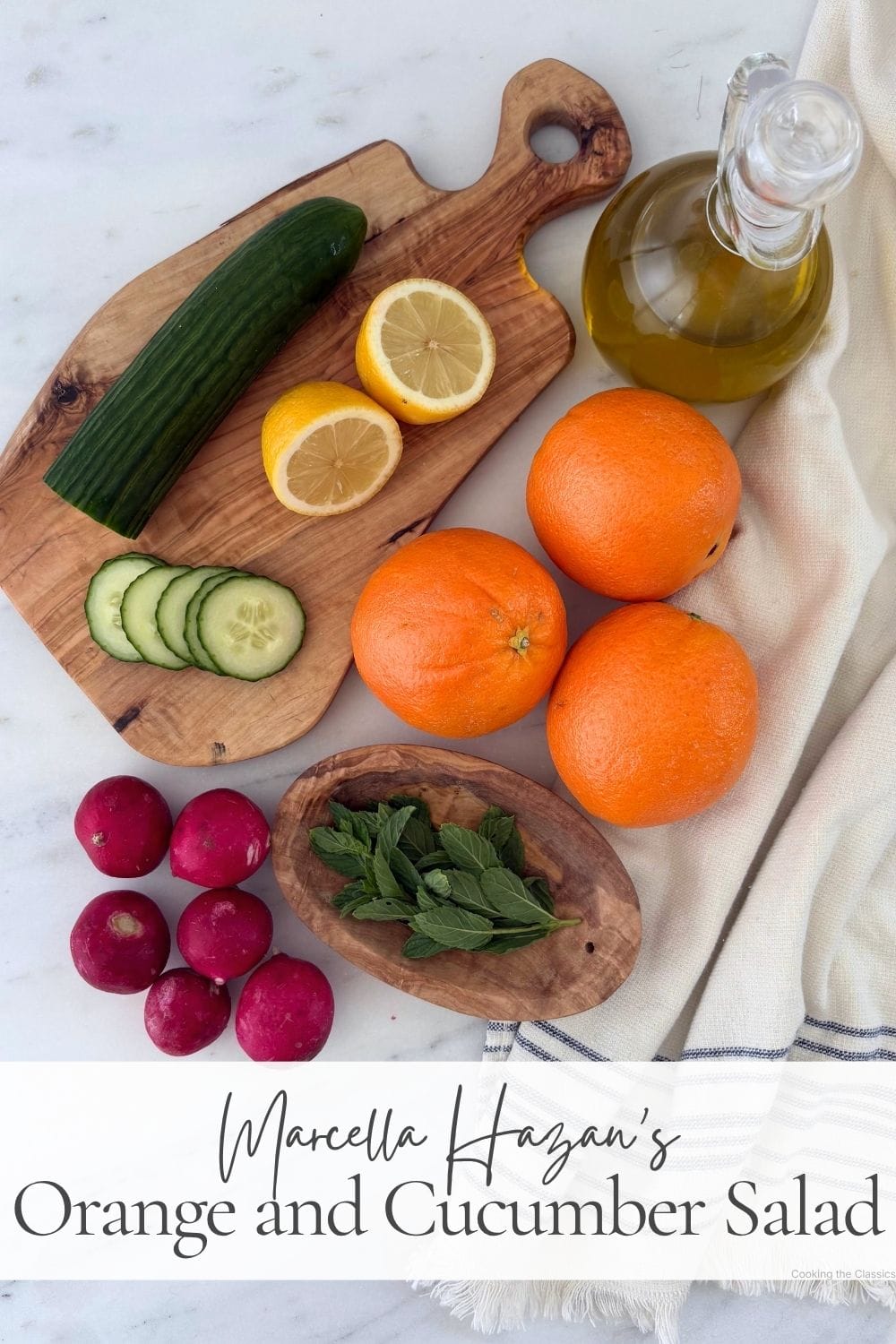 Ingredients for orange and cucumber salad including oranges, English cucumber, radishes, lemon, fresh mint, and olive oil.