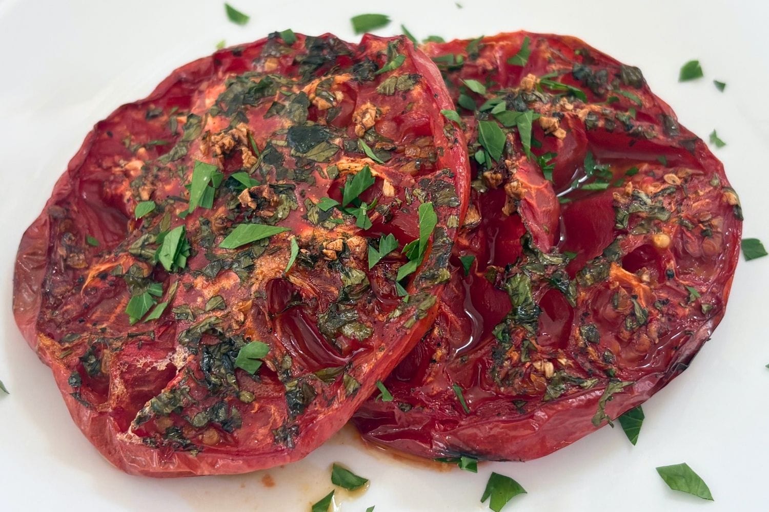 Close-up of Marcella Hazan’s oven-browned tomatoes with garlic, parsley, and concentrated cooking juices.