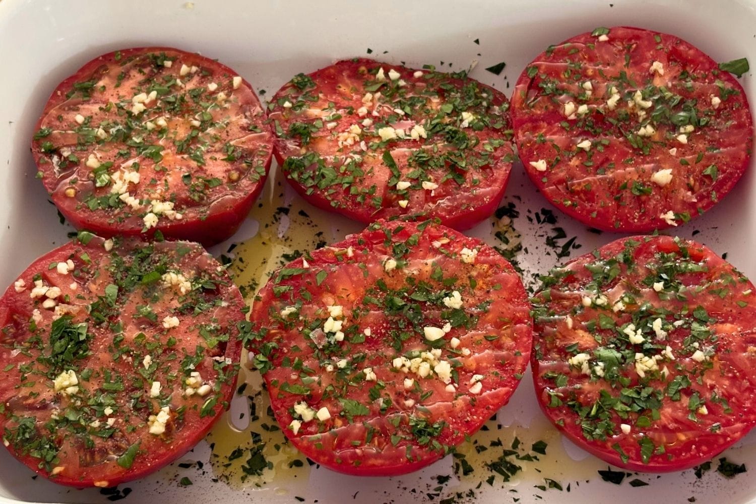 Large tomato halves seasoned with chopped garlic, parsley, olive oil, salt, and pepper before oven-browning.